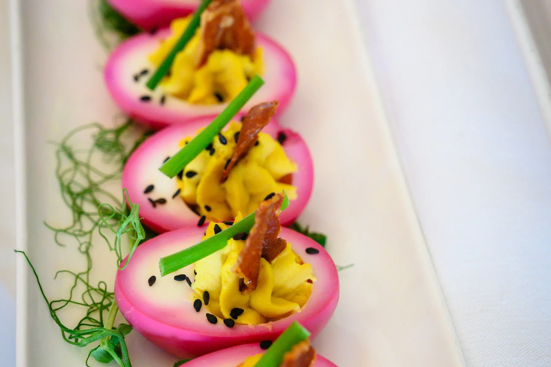Beet-pickled deviled eggs garnished with chives