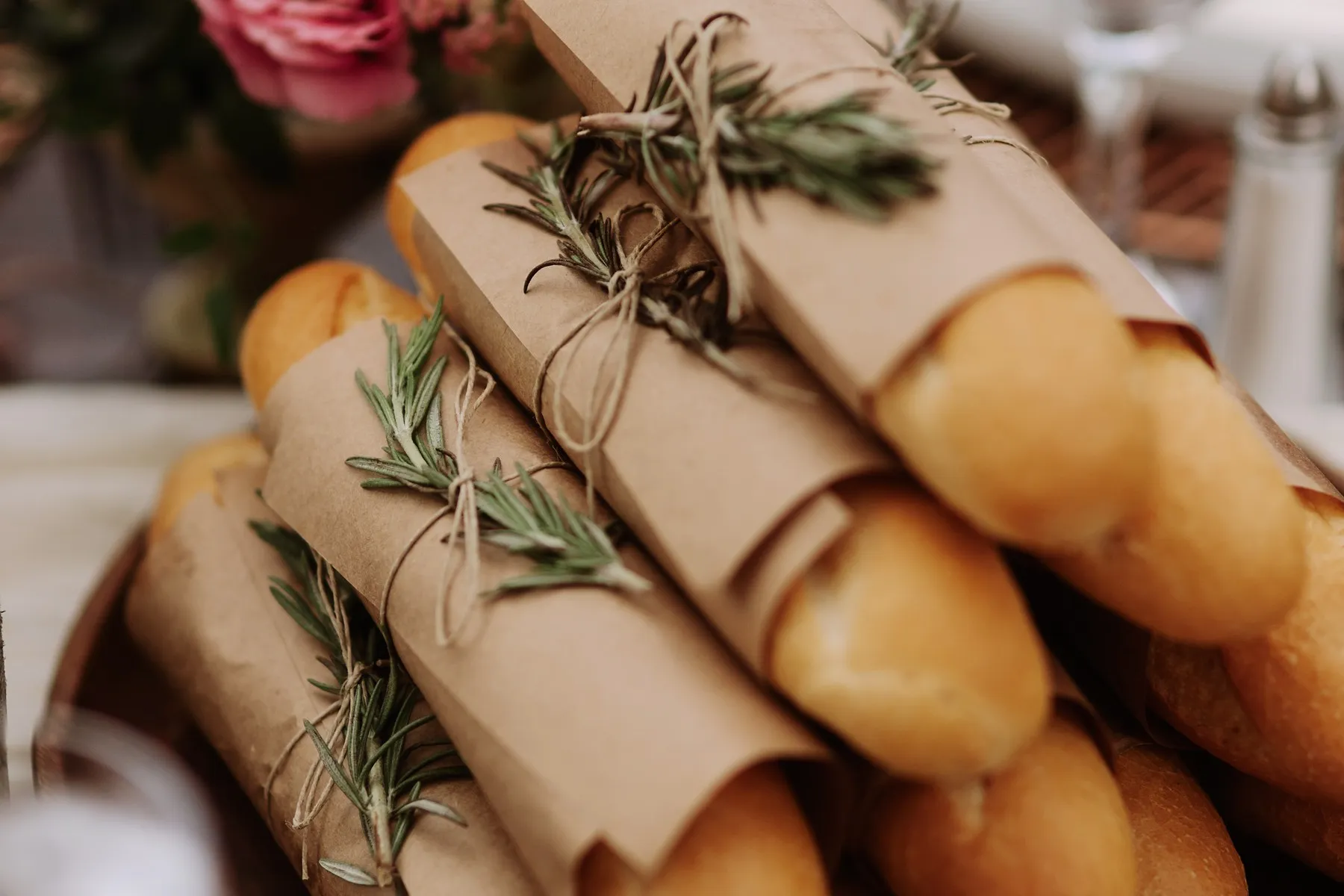 Paper-wrapped baguettes tied with rosemary